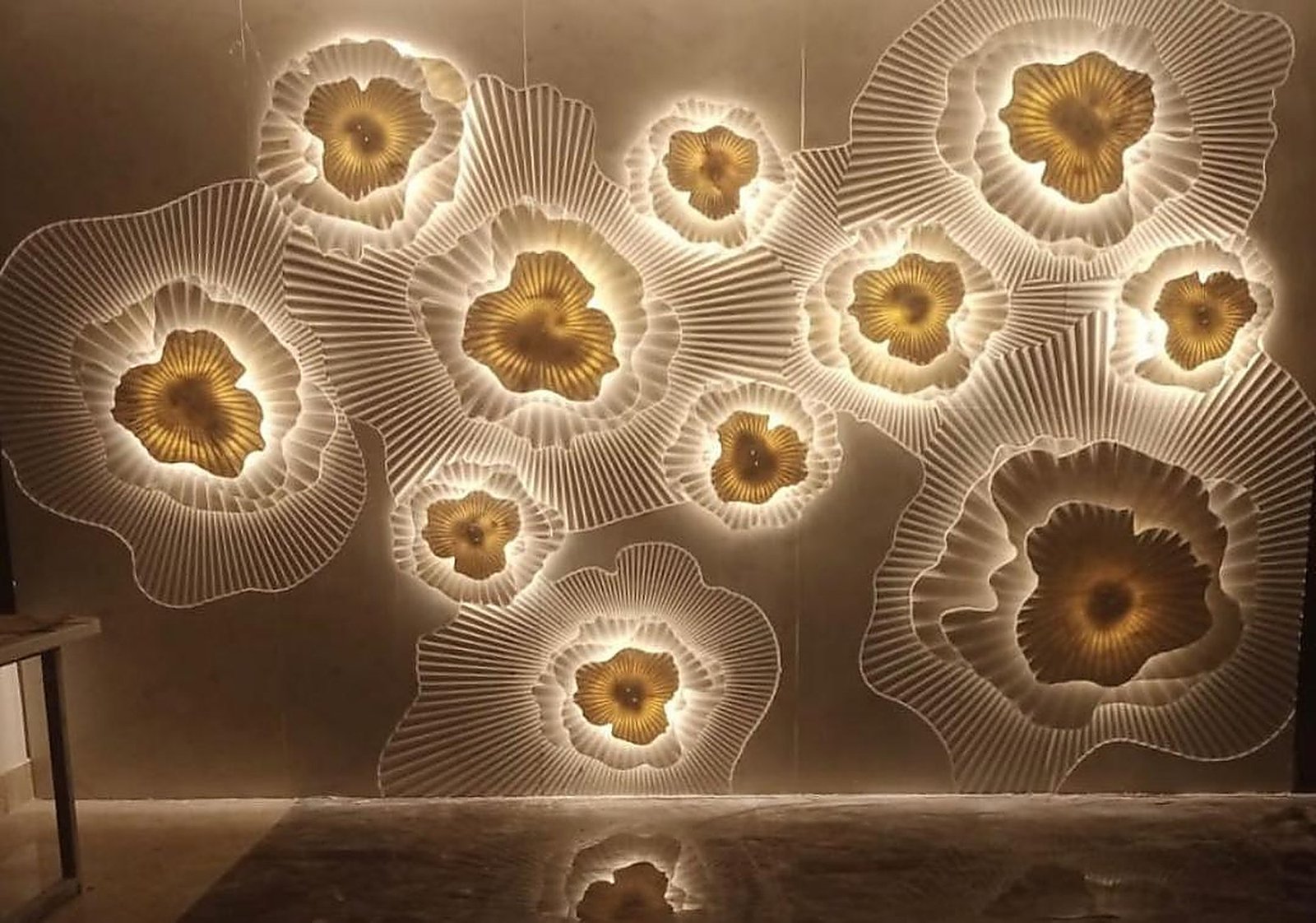 Backlit carved stone floral wall mural with gold centres