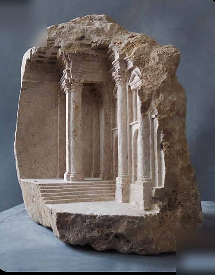 Miniature temple carved inside a raw stone block with columns and steps